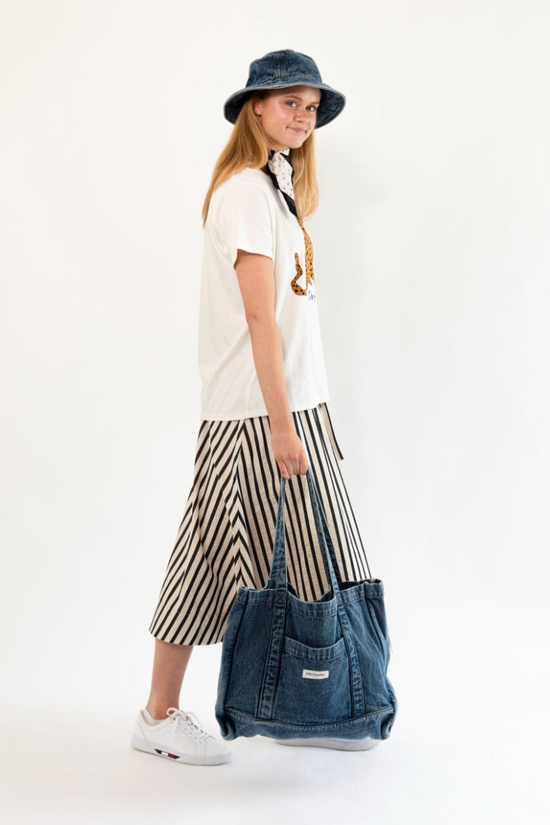 Woman holding a denim bag against a white background